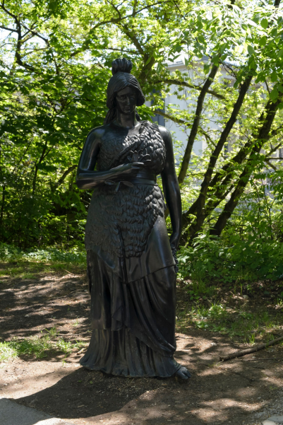 Eine lebensgroße Bronzestatue, die der Bavaria an der Theresienwiese nachempfunden ist, am Wegesrand.