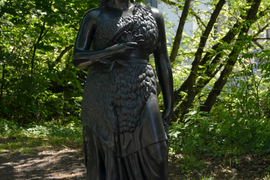 Eine lebensgroße Bronzestatue, die der Bavaria an der Theresienwiese nachempfunden ist, am Wegesrand.