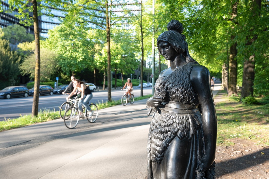 Eine lebensgroße Bronzestatue, die der Bavaria an der Theresienwiese nachempfunden ist, am Wegesrand.