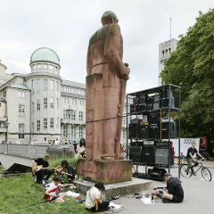 Young people playing music around the Bismarck monument. The German Museum can be seen in the background.