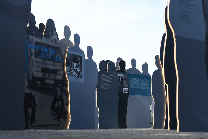 View from the ground into the group of silhouettes, some of which have text printed on them.