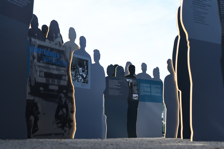View from the ground into the group of silhouettes, some of which have text printed on them.