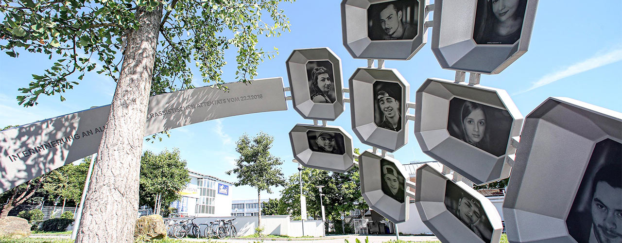 A ginkgo tree surrounded by an oversized ring with portraits of the nine people who were assassinated.