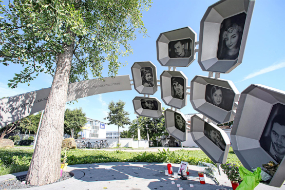 A ginkgo tree surrounded by an oversized ring with portraits of the nine people who were assassinated.