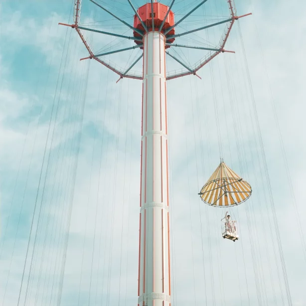 Against the background of a slightly cloudy sky, the view goes from bottom to top along a huge pillar. A kind of gondola is attached to a circular structure at the upper end of the column, floating in the lower right half of the picture. A person waves down from there.