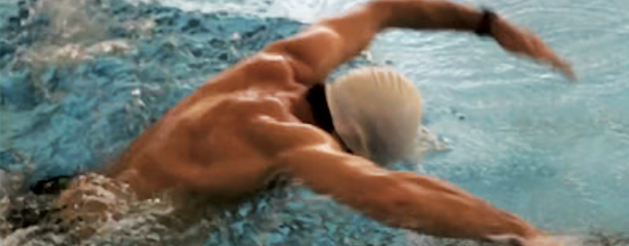 Ein Schwimmer beim Kraulstil im Schwimmbecken Olympiaschwimmhalle