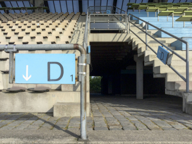 Die Aufnahme zeigt den Blick die Tribüne empor und auf den Durchgang durch die Tribüne hindurch