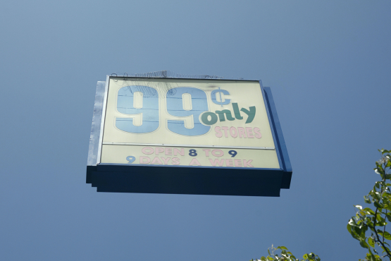 The motif shows an advertising billboard with the slogan "99 Cents only stores" against a blue sky, which seems to float freely above the earth without any supporting structures.