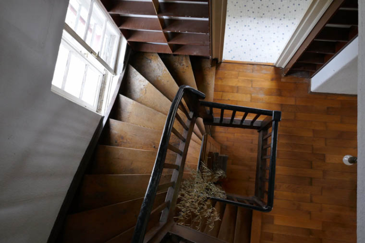 Blick von oben in ein altes hölzernes Treppenhaus.