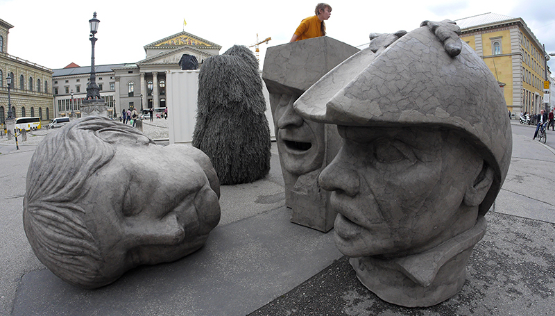 Three grey sculptures in the form of oversized heads can be seen on Max-Joseph-Platz. The heads bear the likenesses of Angela Merkel, ECB President Mario Draghi and Dutty Boukman, the leader of the first slave rebellion in Haiti in 1791.