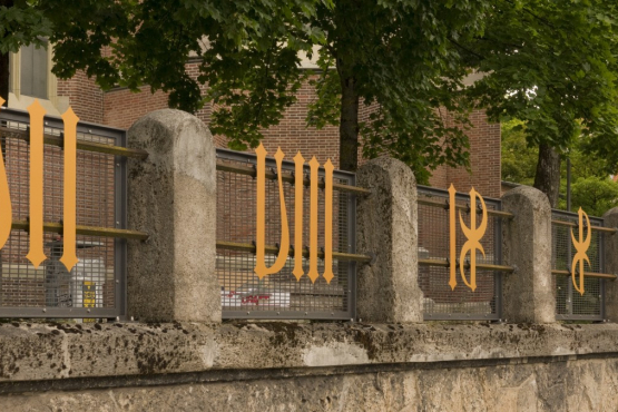 Several golden metal numerals are attached to the fence in front of the Heilig-Kreuz-church on Giesinger Berg hill.