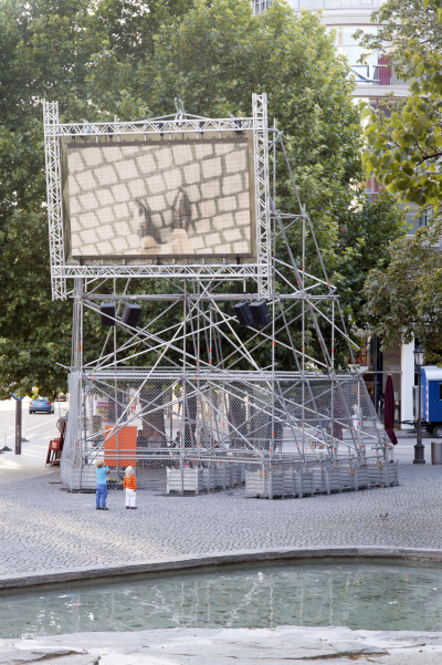 A metal scaffolding with a video screen mounted on it shows Nevin Aladağ's video work "Top View" at Munich's Rindermarkt.