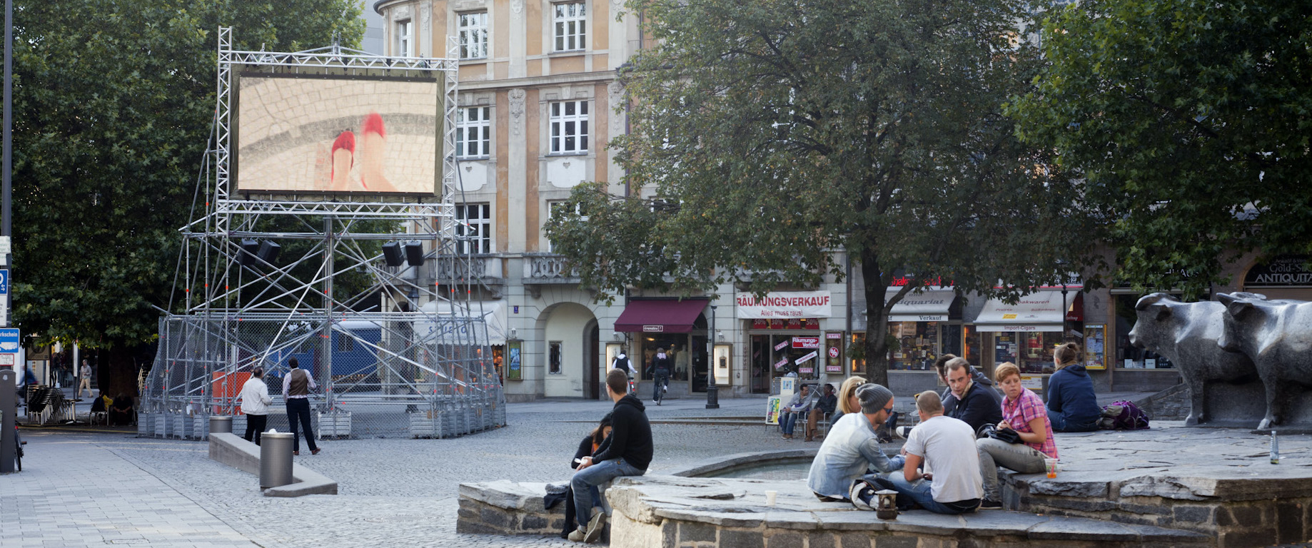 A metal scaffolding with a video screen mounted on it shows Nevin Aladağ's video work "Top View" at Munich's Rindermarkt.