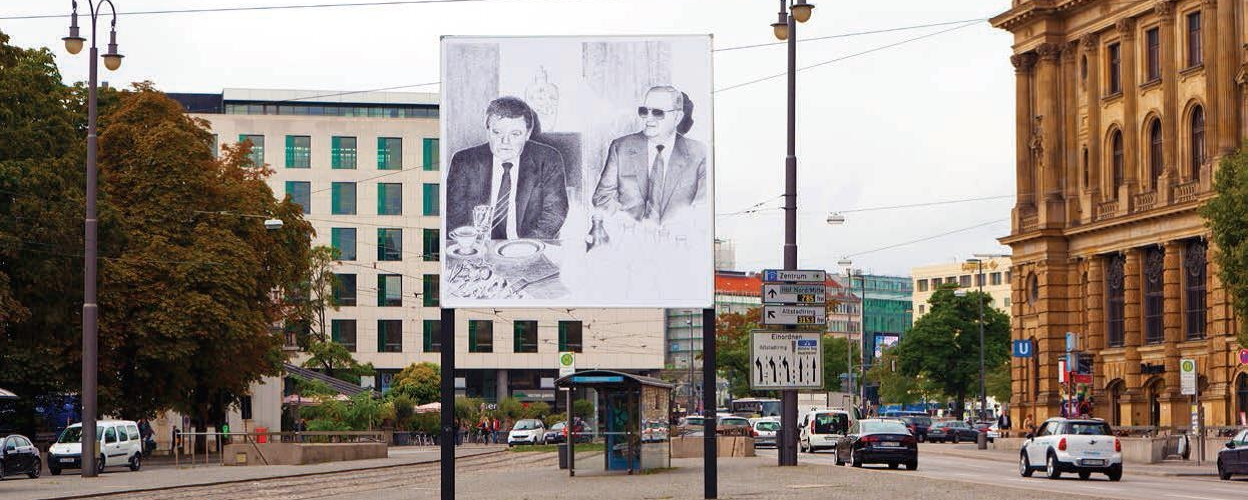 Das Motiv auf dem Billboard am Lenbachplatz zeigt die Tuschezeichnung einer Fotografie eines Treffens zwischen Franz Josef Strauß und Alexander Schalck-Golodkowski, Leiter des DDR-Außenhandelsministeriums.