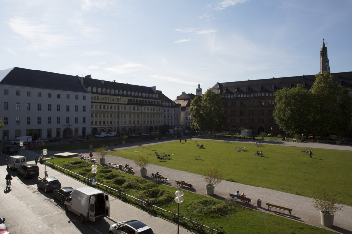 View of the green area of the Marienhof with an installation by artist Martin Schmidt seen from above. The artist has modelled a crater landscape on an approx. 7 m wide strip of grass on the northern edge of the Marienhof using heaped up and excavated earth. The various craters are overgrown with grass.