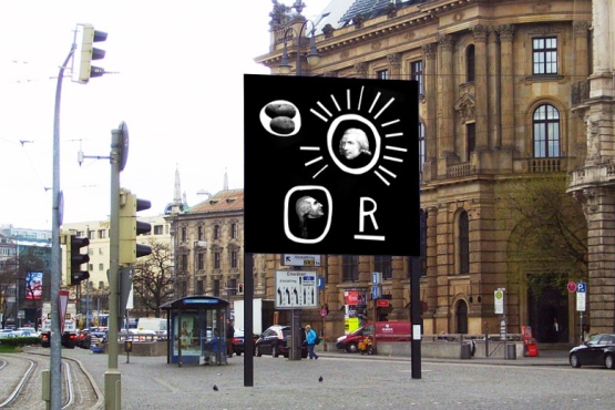 Side view of the billboard on Lenbachplatz, looking towards the city centre. The billboard shows a work by the artist Martin Fengel. It shows four objects on a black background. A white underlined "R" in capital letters. A white circle with a grey image of two potatoes. A white circle with rays emanating from the side, in the centre of which is a black and white portrait of Count Rumford. A second circle with a black and white portrait of a man in profile, possibly also Count Rumford.