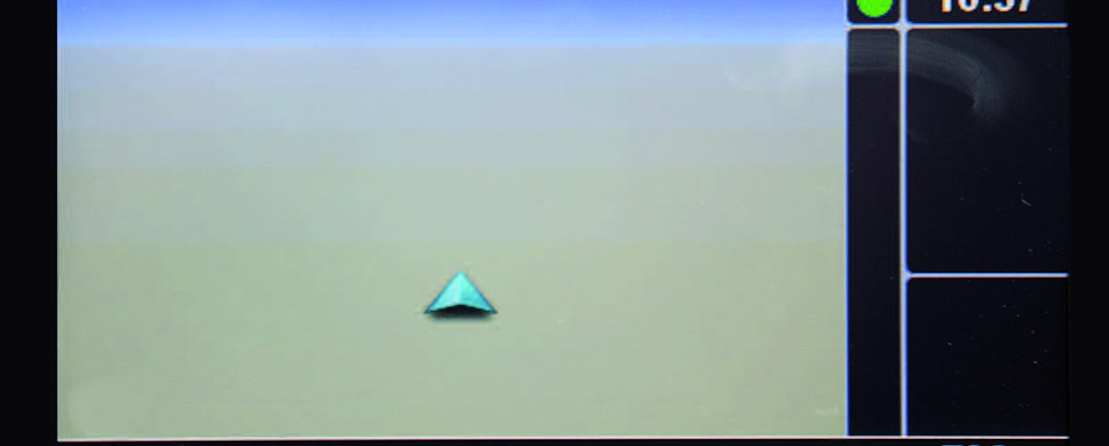 Bildschirmaufnahme eines Navigationsdisplays mit einem türkisen Navigationspfeil in der Mitte. Auf der rechten Seite des Displays wird in weißer Schrift die Uhrzeit (10:37) und die Temperatur (7 Grad) angezeigt.
