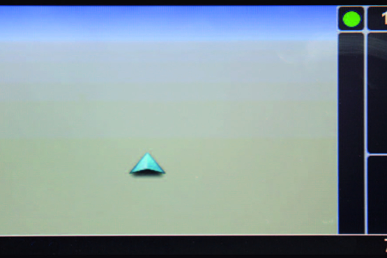 Bildschirmaufnahme eines Navigationsdisplays mit einem türkisen Navigationspfeil in der Mitte. Auf der rechten Seite des Displays wird in weißer Schrift die Uhrzeit (10:37) und die Temperatur (7 Grad) angezeigt.