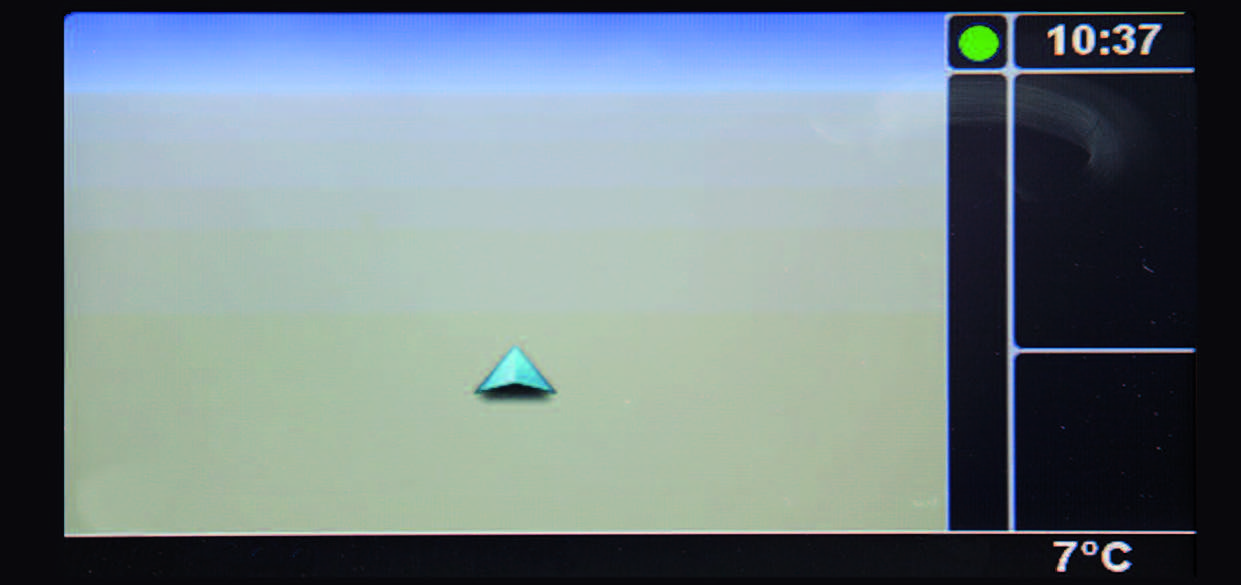 Bildschirmaufnahme eines Navigationsdisplays mit einem türkisen Navigationspfeil in der Mitte. Auf der rechten Seite des Displays wird in weißer Schrift die Uhrzeit (10:37) und die Temperatur (7 Grad) angezeigt.