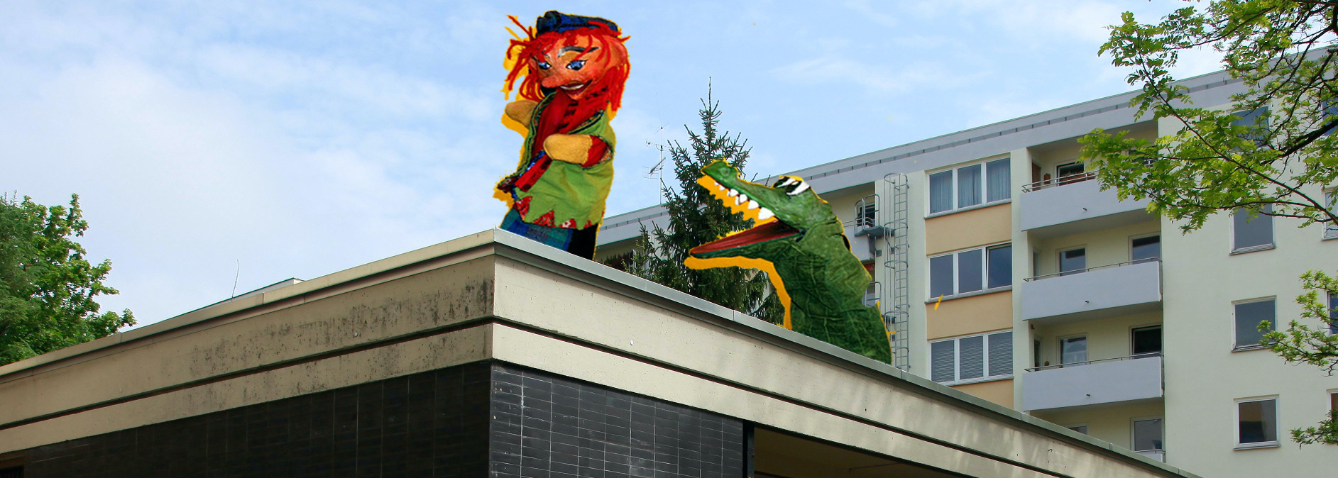 The picture shows a photo collage. A single-storey building can be seen in the foreground and a multi-storey apartment block in the background. A punch and a hand puppet crocodile figure are retouched onto the roof of the single-storey house, performing a kind of Punch-and-Judy-show on the roof.