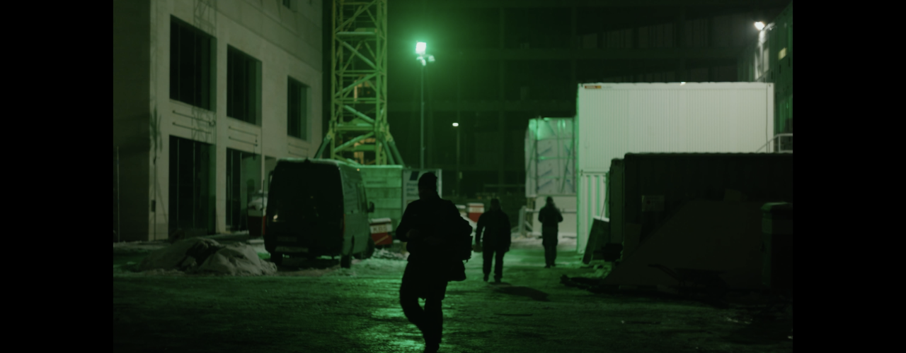 Night-time shot of a building site with the outlines of three people