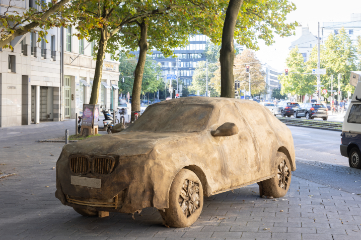 A clay SUV stands on a busy street corner in front of a bustling cityscape.